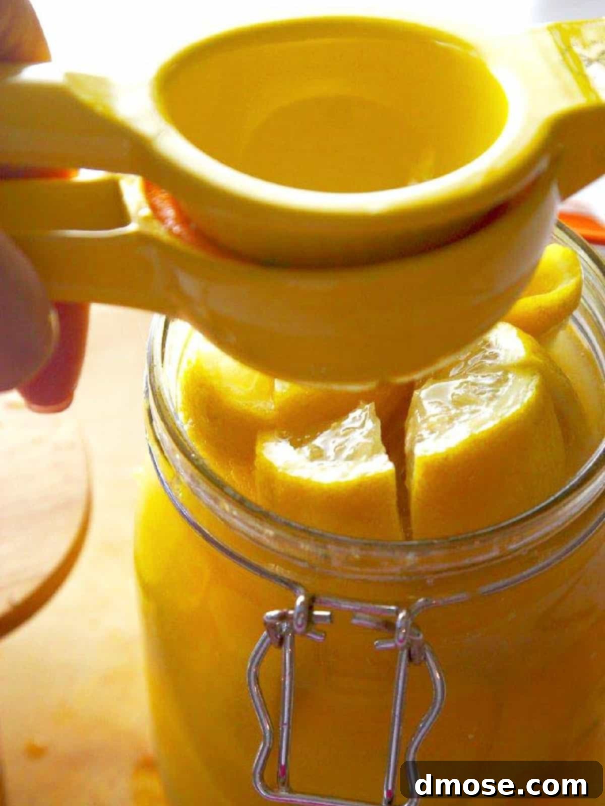 Using a lemon juicer to add lemon juice into the clamp jar.
