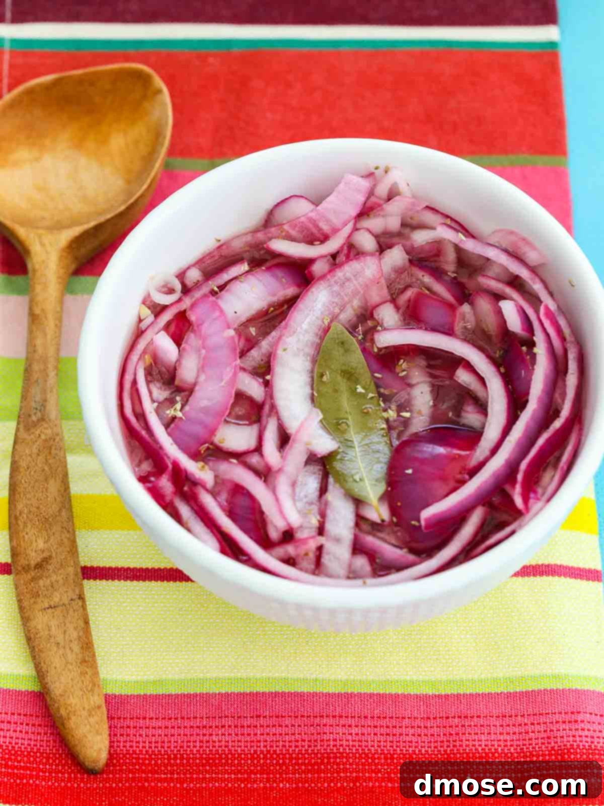 Mexican Pickled Red Onions in bowl with spoon, just after preparation.