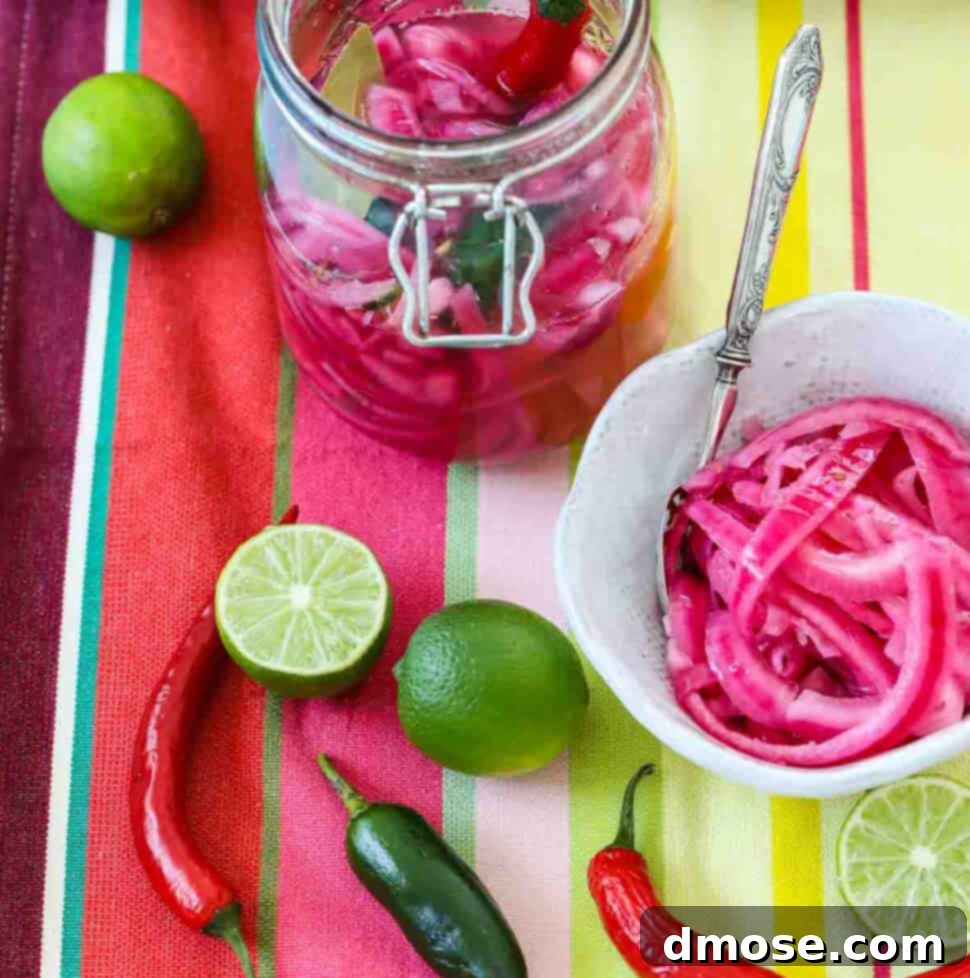Mexican pickled red onions in a clamp jar and white bowl with chiles and limes on a colorful striped cloth.