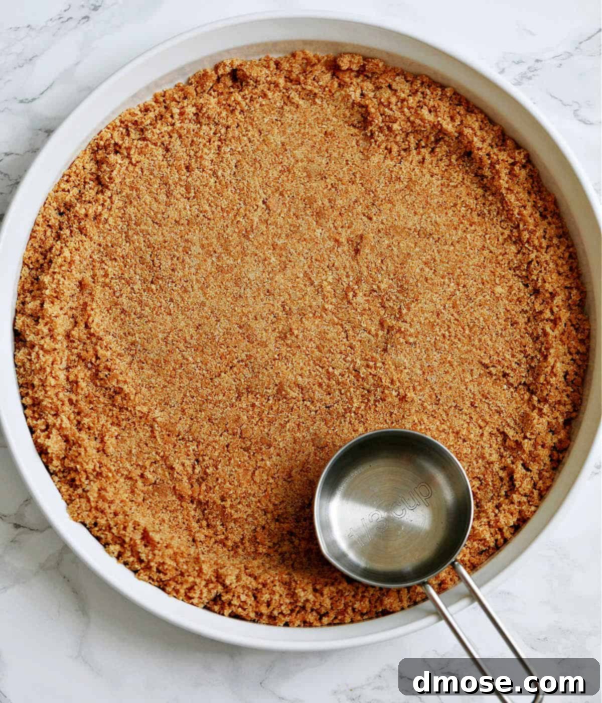 A perfectly formed graham cracker crust chilling in a glass pie plate, ready for the filling.