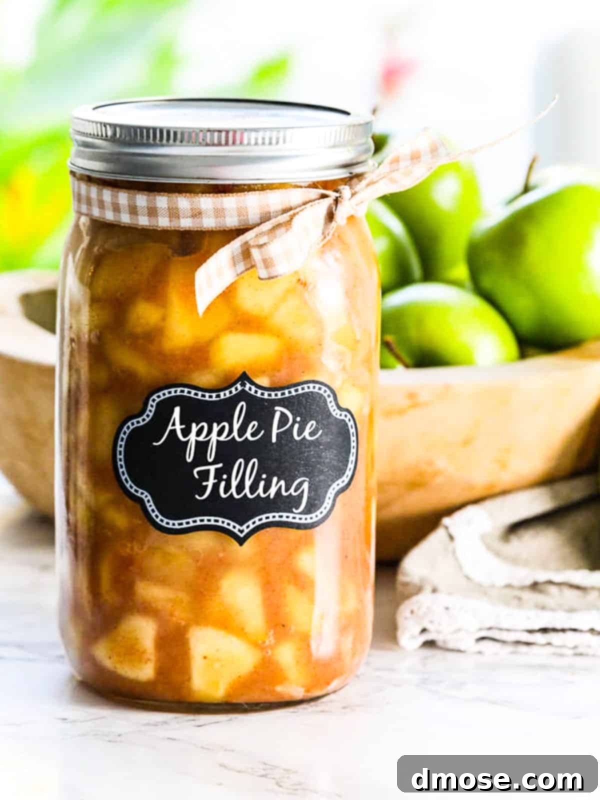 A jar of homemade apple pie filling ready for baking.