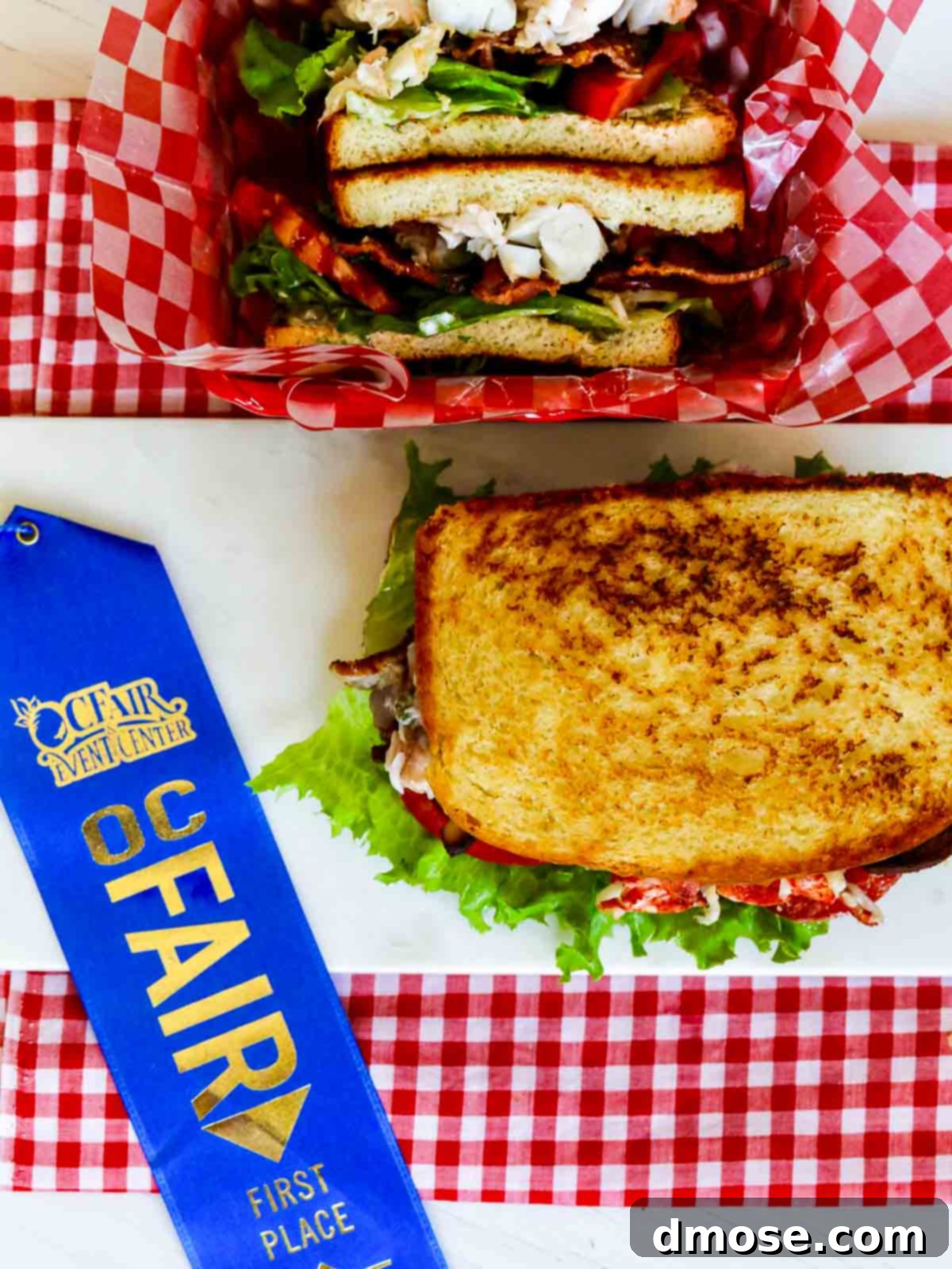 The coveted blue ribbon prominently displayed next to the beautifully presented Lobster BLT Sandwich, symbolizing culinary excellence and achievement.