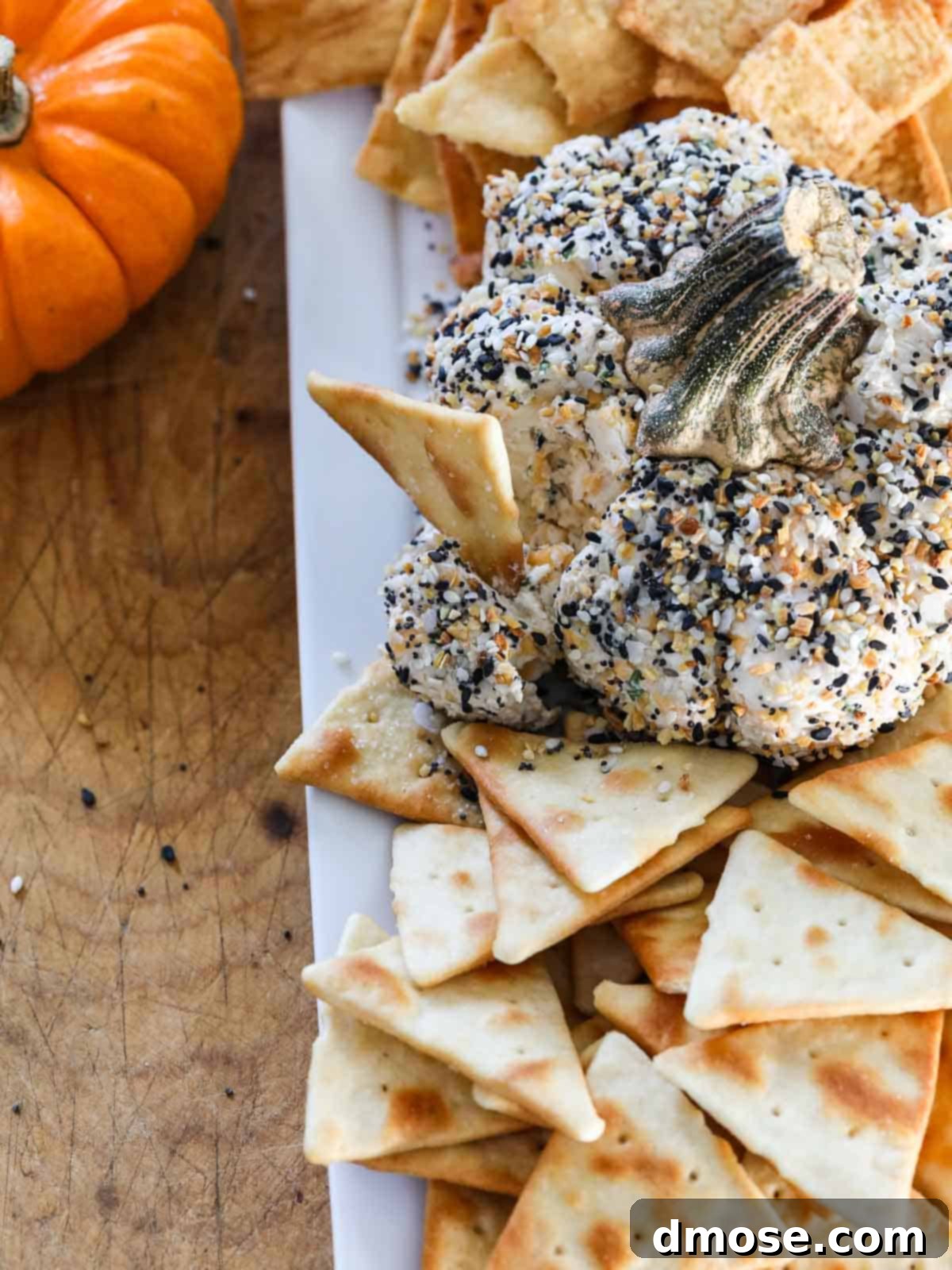 Harvest Everything Bagel Pumpkin Cheese Ball 6 A chip scooping out a portion of the Everything Bagel Cheese Ball.