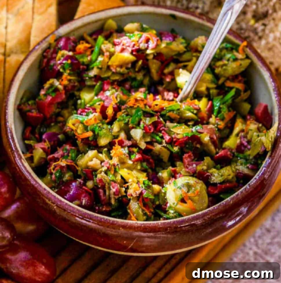 A vintage French ceramic bowl filled with freshly made meyer lemon olive tapenade with a silver spoon and sliced baguette to eat as an appetizer.