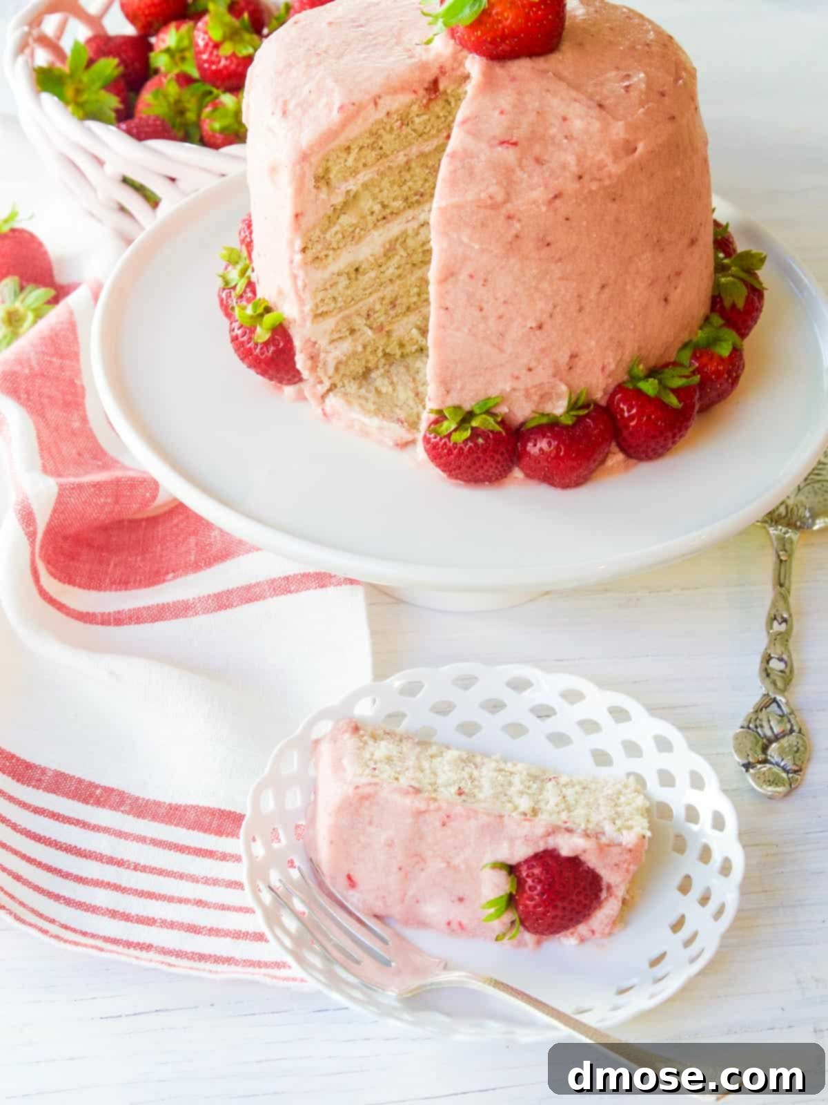A slice removed from a beautifully decorated strawberry cake.