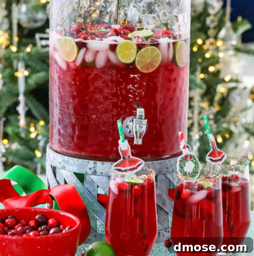 A big glass beverage container filled with holiday Christmas Punch.
