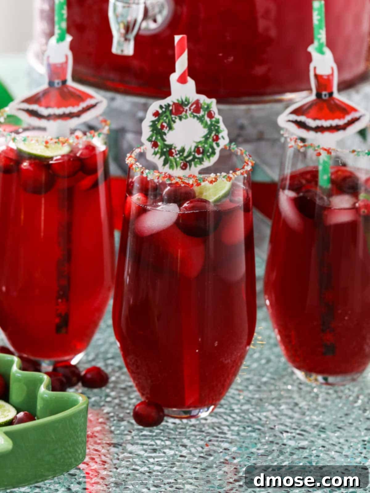 Close-up of Christmas Punch in a glass, showcasing the frothy top and colorful garnishes.