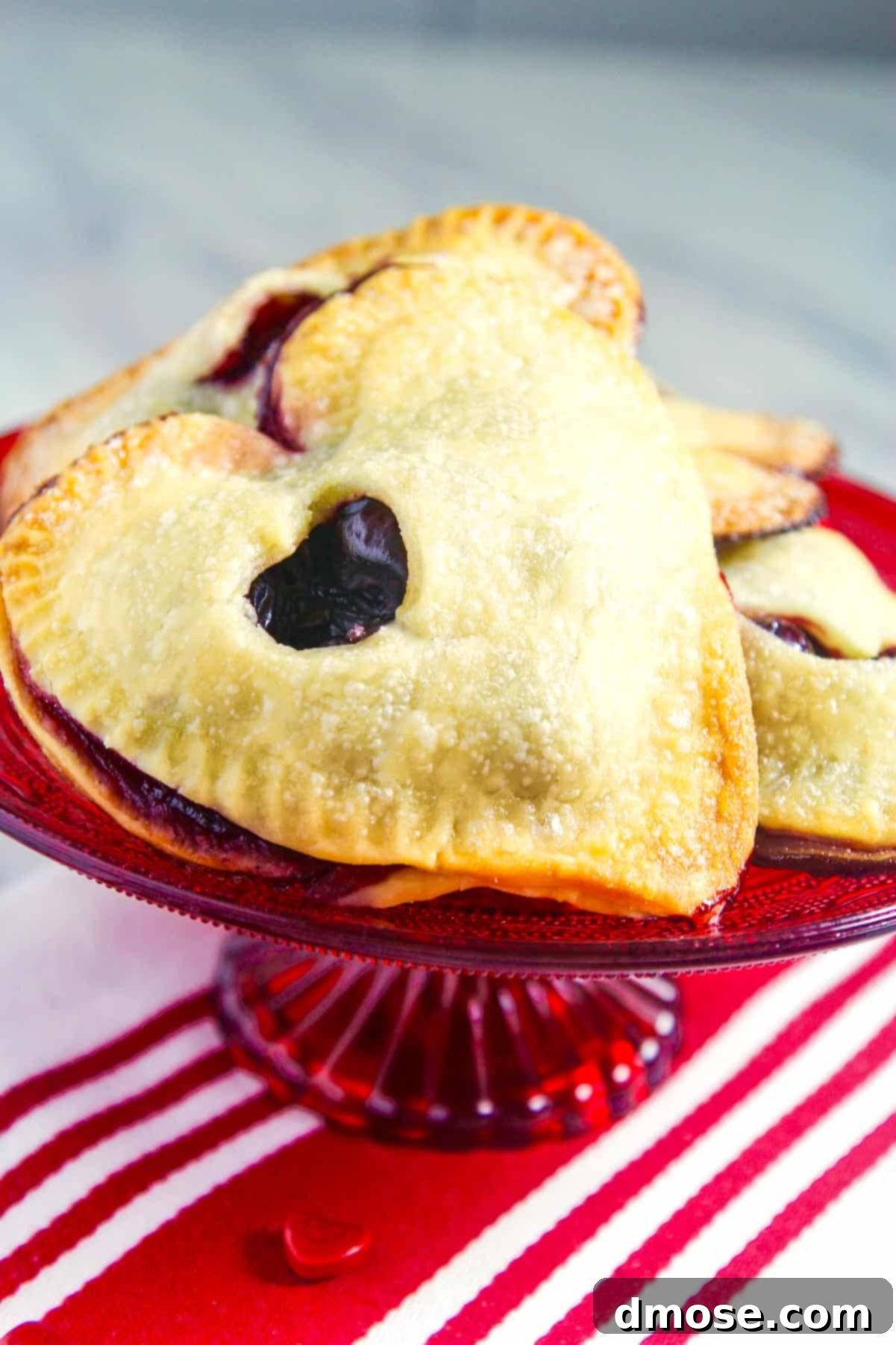 A single chocolate cherry hand pie presented on a white plate, garnished with a sprinkle of powdered sugar, ready to be served.