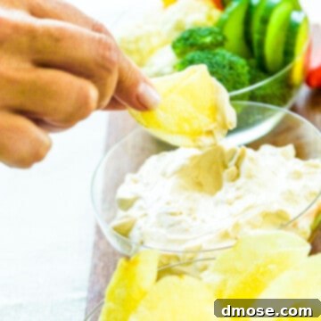 A lady dipping a potato chip into easy sour cream onion dip.