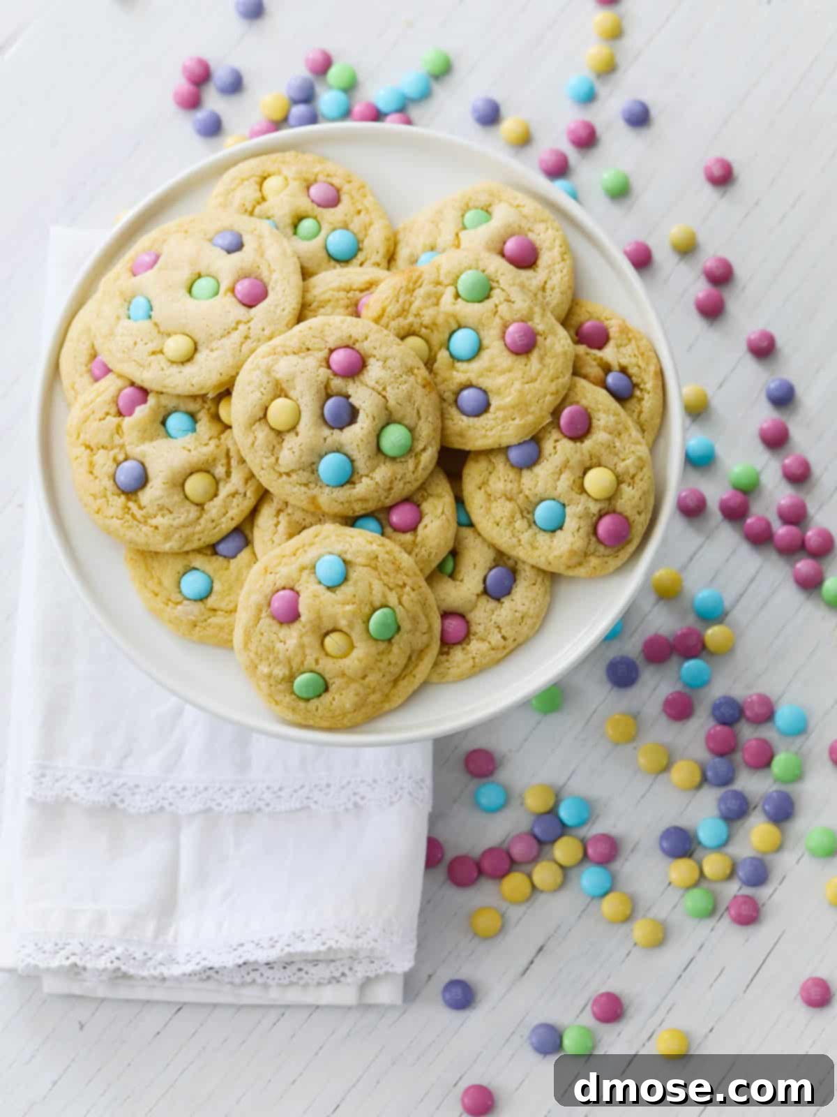 A plate of freshly baked pastel M&M cake mix cookies, showcasing their soft, chewy texture and colorful toppings.