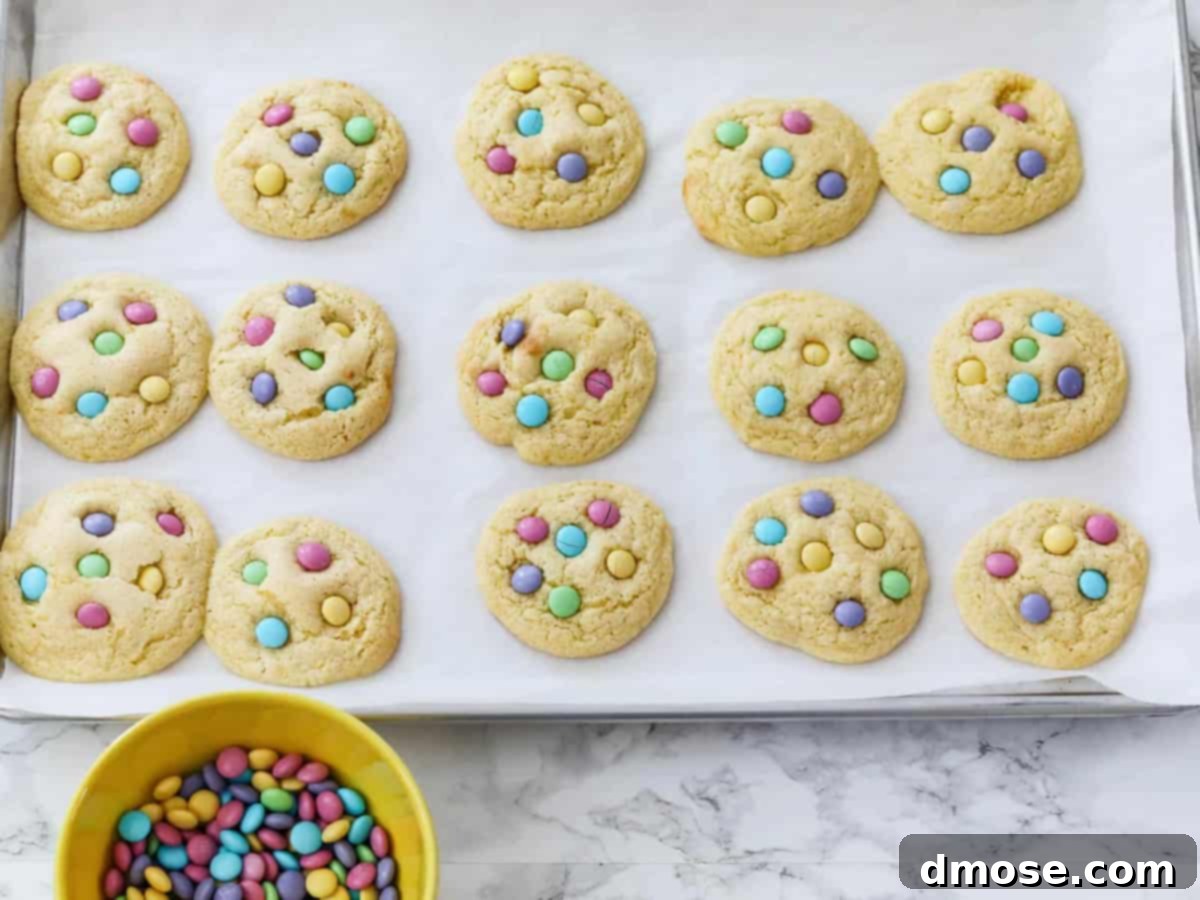 A white plate showcasing a pile of freshly baked cake mix cookies, topped with colorful M&Ms, ready to be enjoyed.