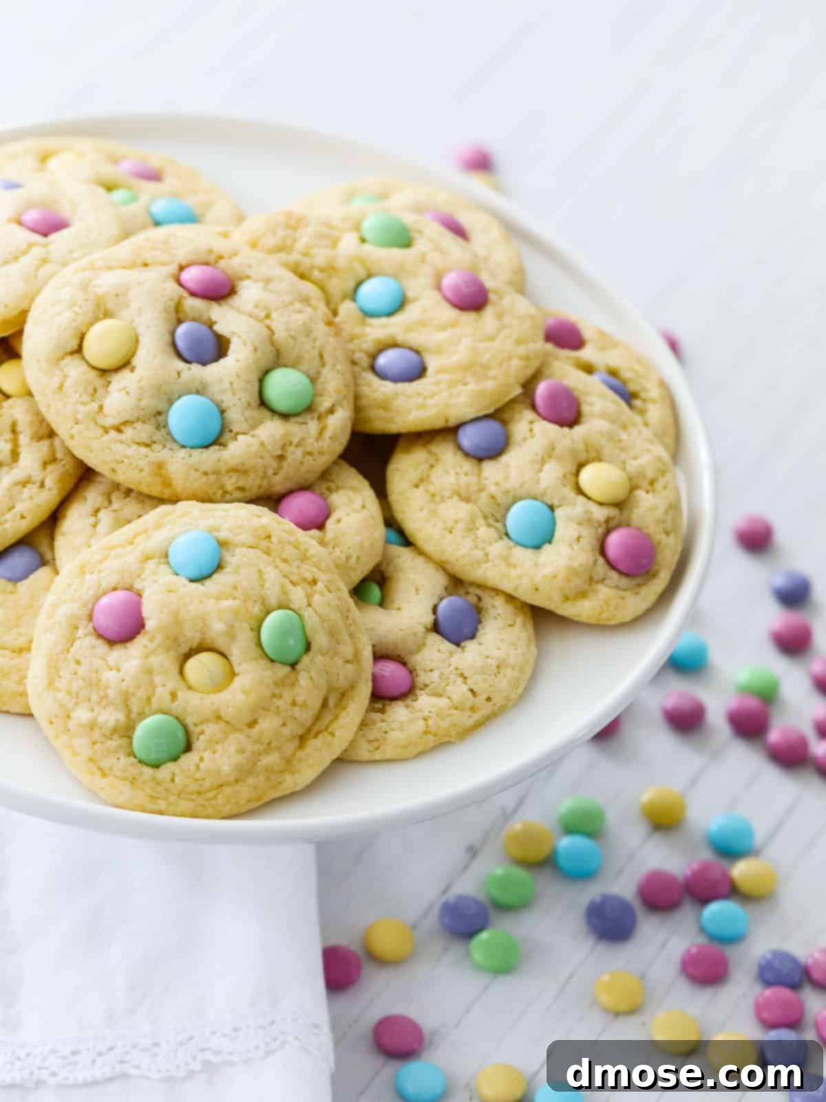 A close-up shot of a single cake mix cookie with pastel M&Ms, highlighting its chewy texture and colorful toppings.
