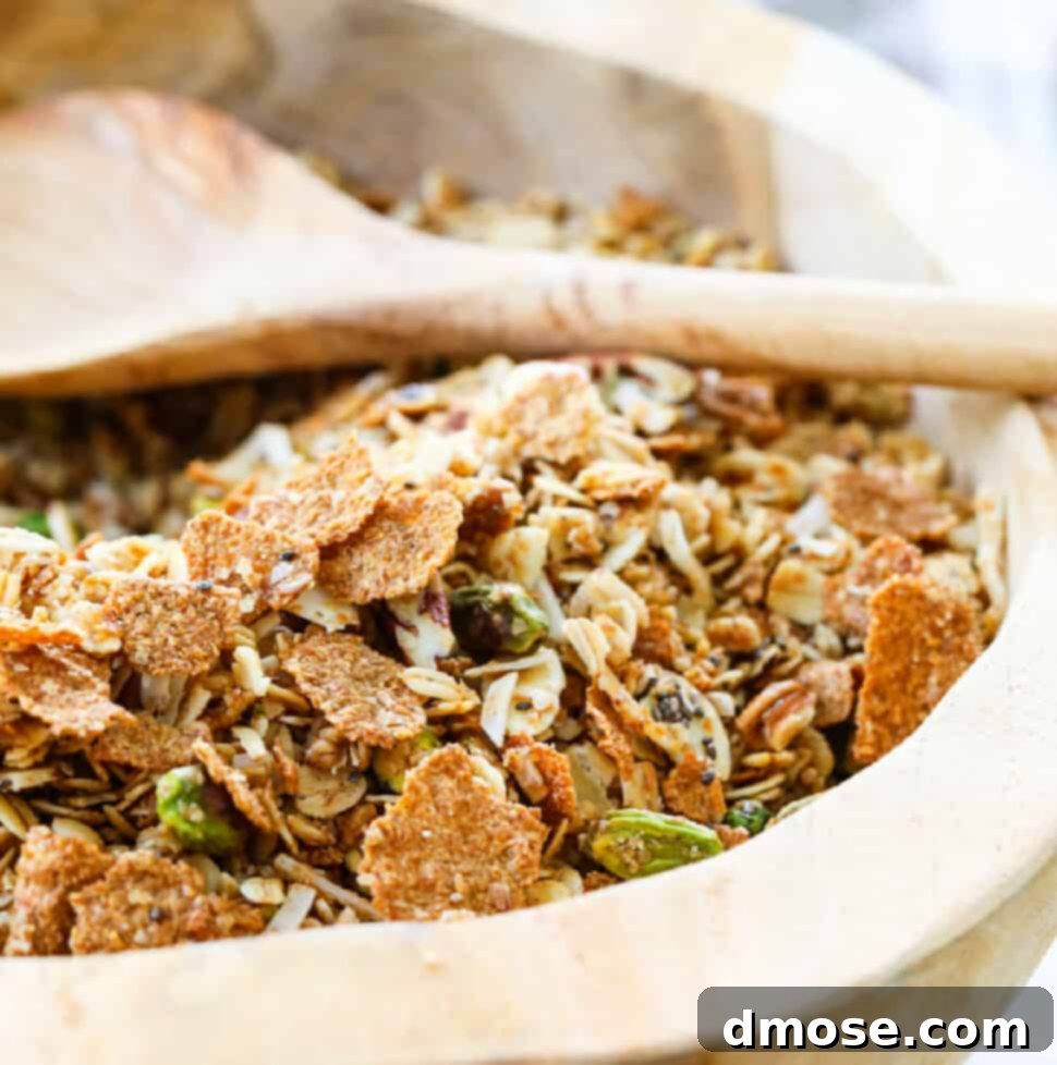 A wooden bowl filled with granola and a wooden spoon.