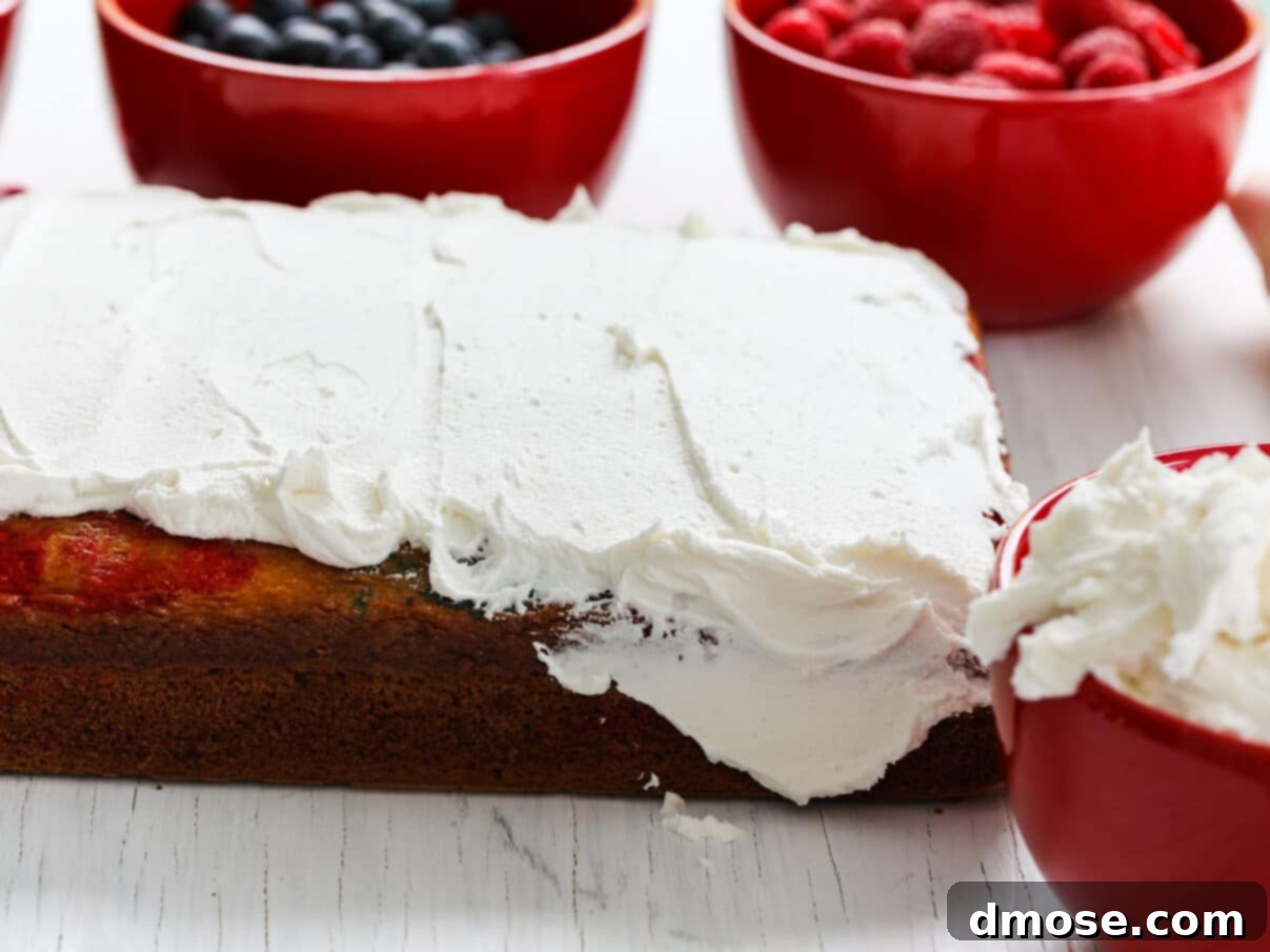 White buttercream frosting being applied to an American Flag Cake.