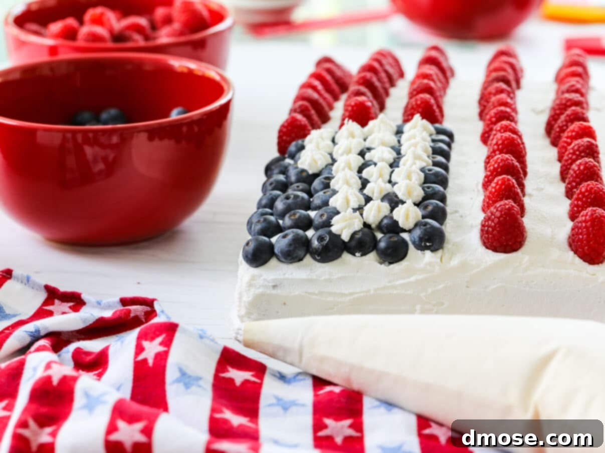 Piping white stars onto the blueberry field of an American Flag July 4th cake.