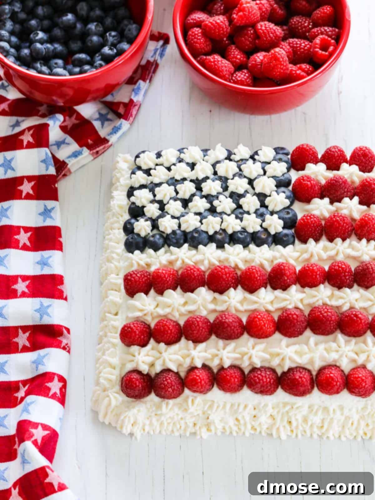 A Flag Cake with bowls of fresh berries ready for decoration on July 4th.