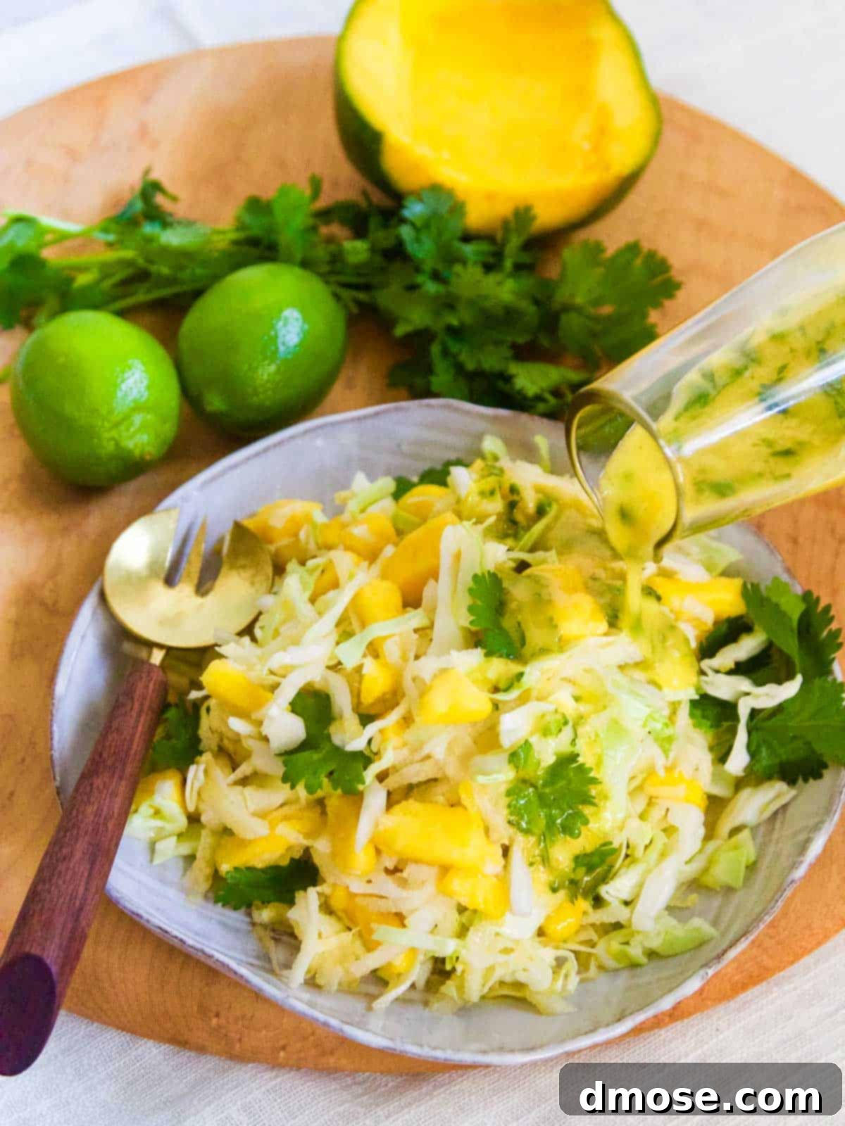 Pouring mango lime vinaigrette over the fresh mango jicama slaw.