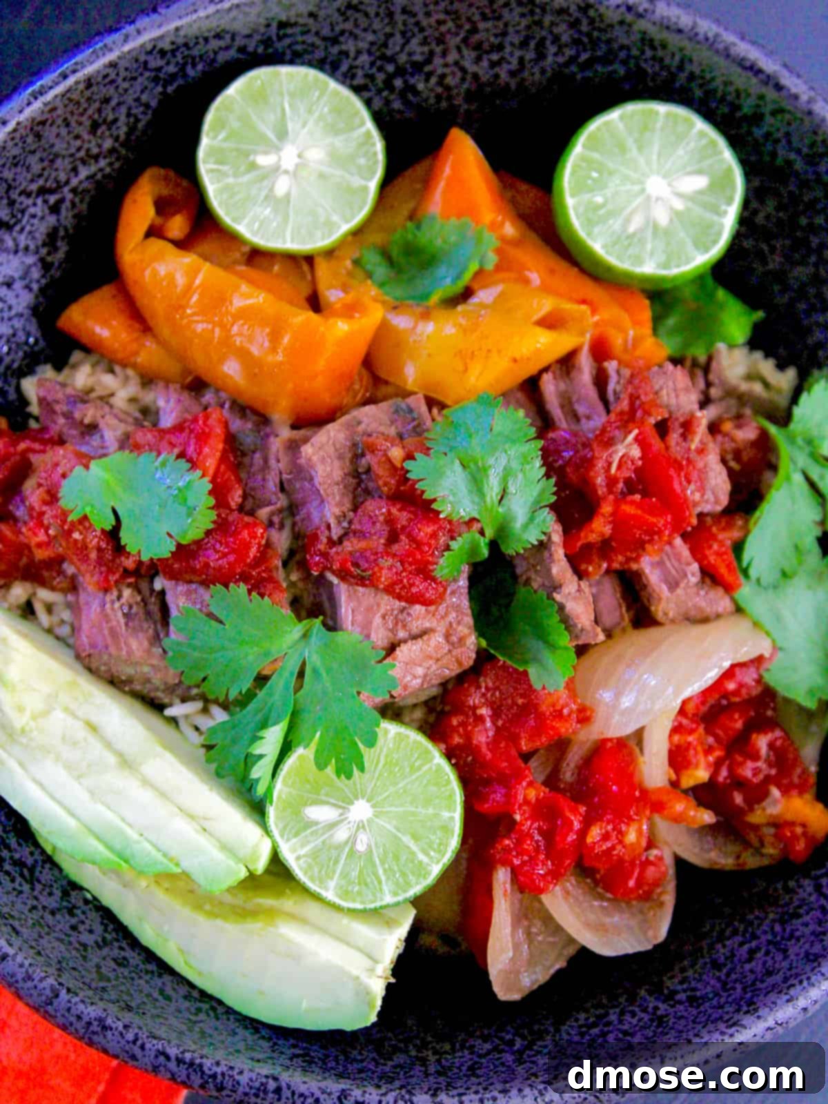 Slow Cooker Fall Apart Beef 3 Close-up of shredded beef mixed with bell peppers and onions in a bowl.