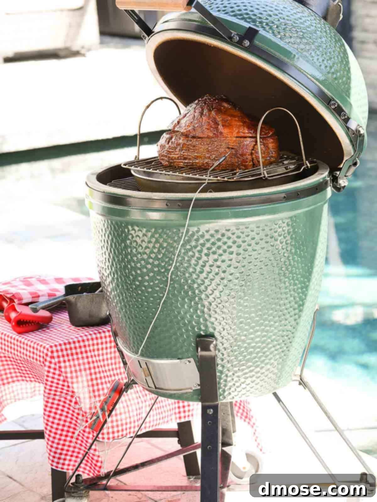 Rich Double Smoked Ham Zesty Orange Honey Glazed 13 A Big Green Egg smoker with various smoking accessories and tools laid out, emphasizing the gear needed for the recipe.