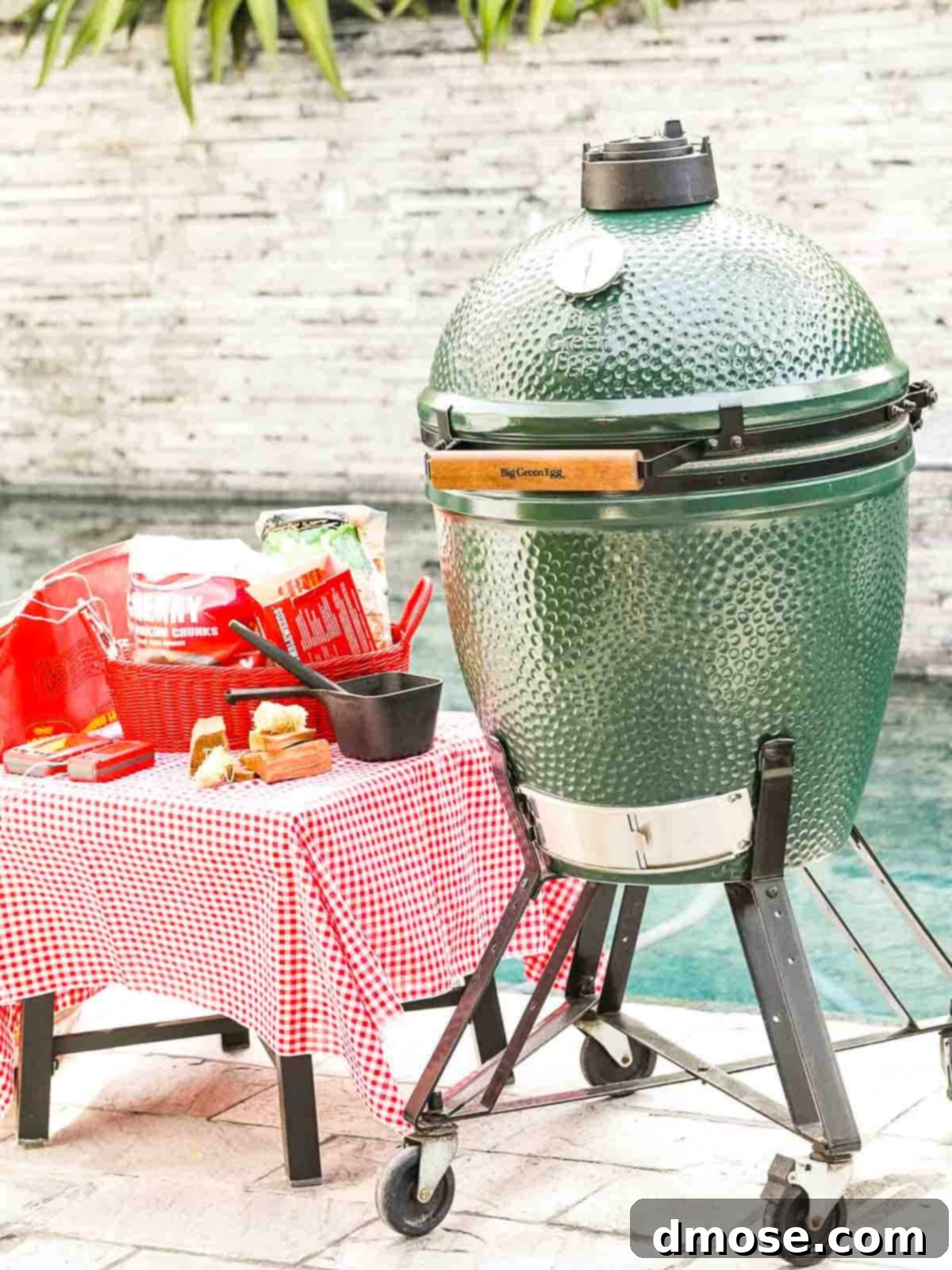 Rich Double Smoked Ham Zesty Orange Honey Glazed 14 A Big Green Egg smoker positioned by a pool, surrounded by various smoking tools and gear.