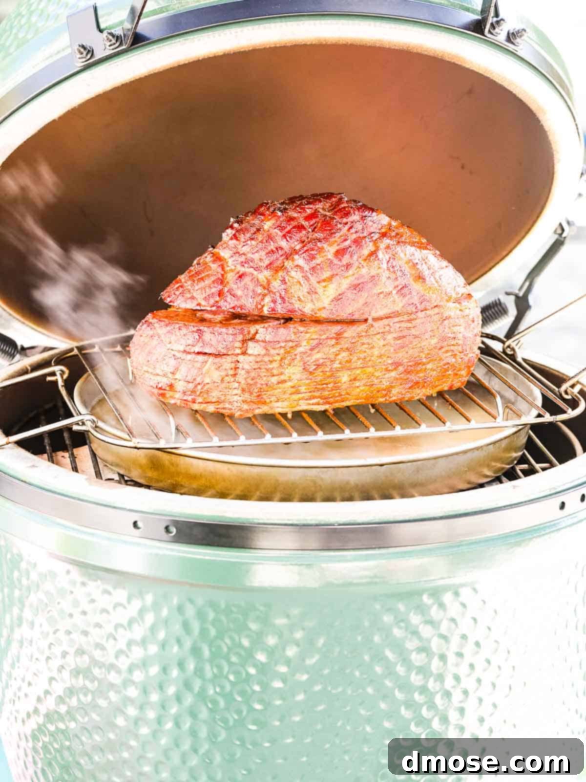 Rich Double Smoked Ham Zesty Orange Honey Glazed 15 A holiday ham smoking inside a Big Green Egg, showcasing the indirect cooking setup.