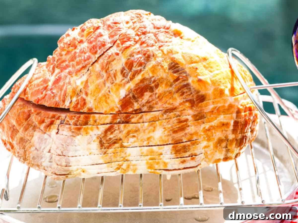 Rich Double Smoked Ham Zesty Orange Honey Glazed 6 A spiral smoked ham resting on a wire rack over a pan inside a smoker, ready for glazing.