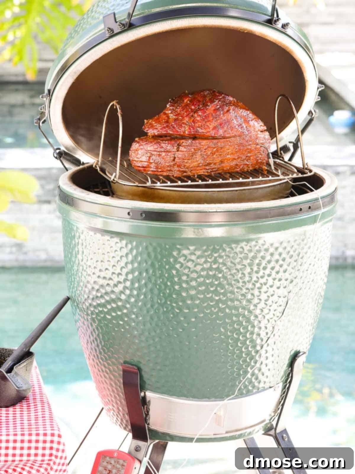 Rich Double Smoked Ham Zesty Orange Honey Glazed 8 A close-up of a juicy, glazed smoked ham with rich color, ready to be sliced, taken from a Big Green Egg smoker.