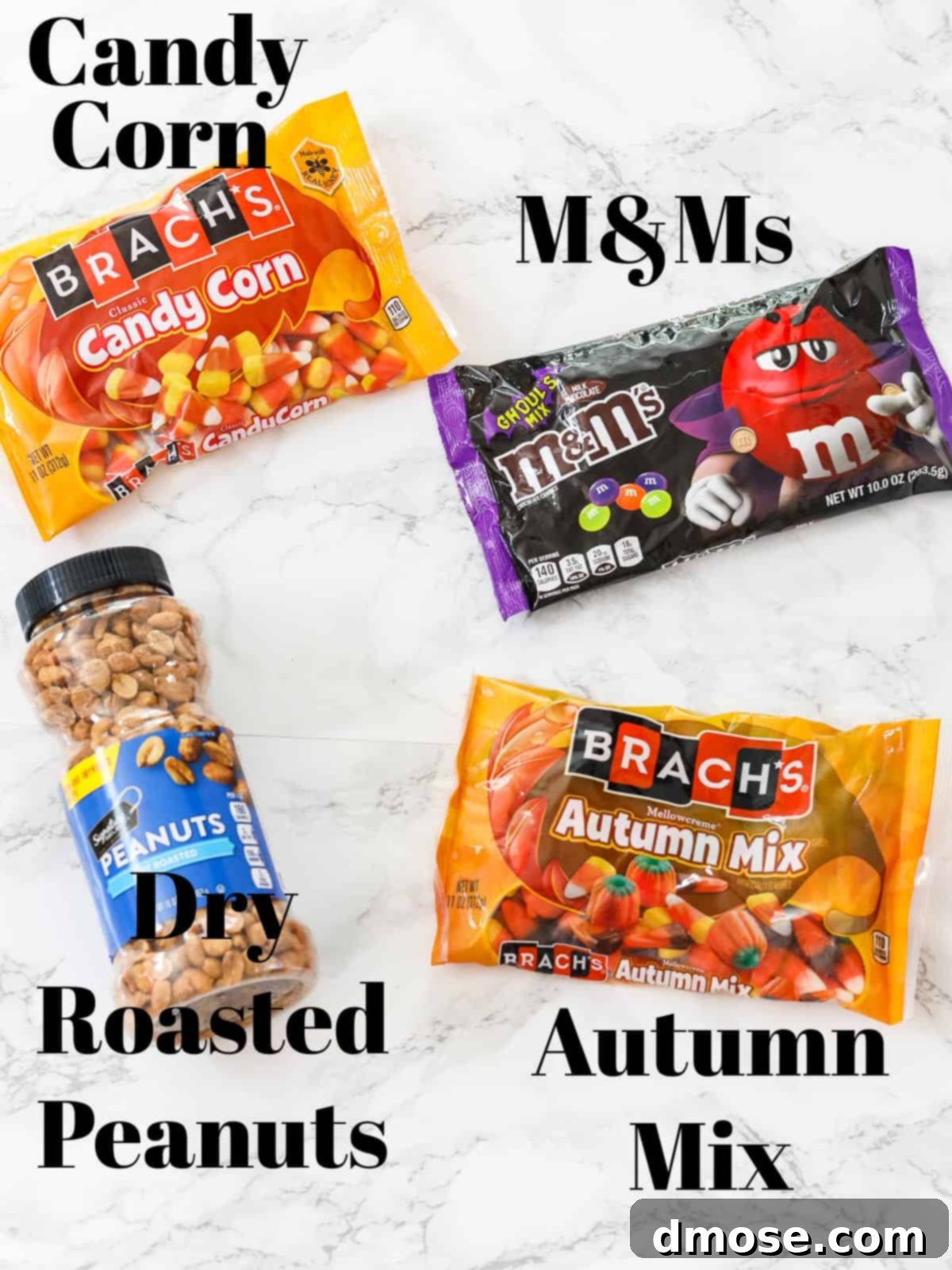 Various ingredients for Fall Snack Mix laid out: bags of candy corn, M&Ms, and a jar of peanuts.