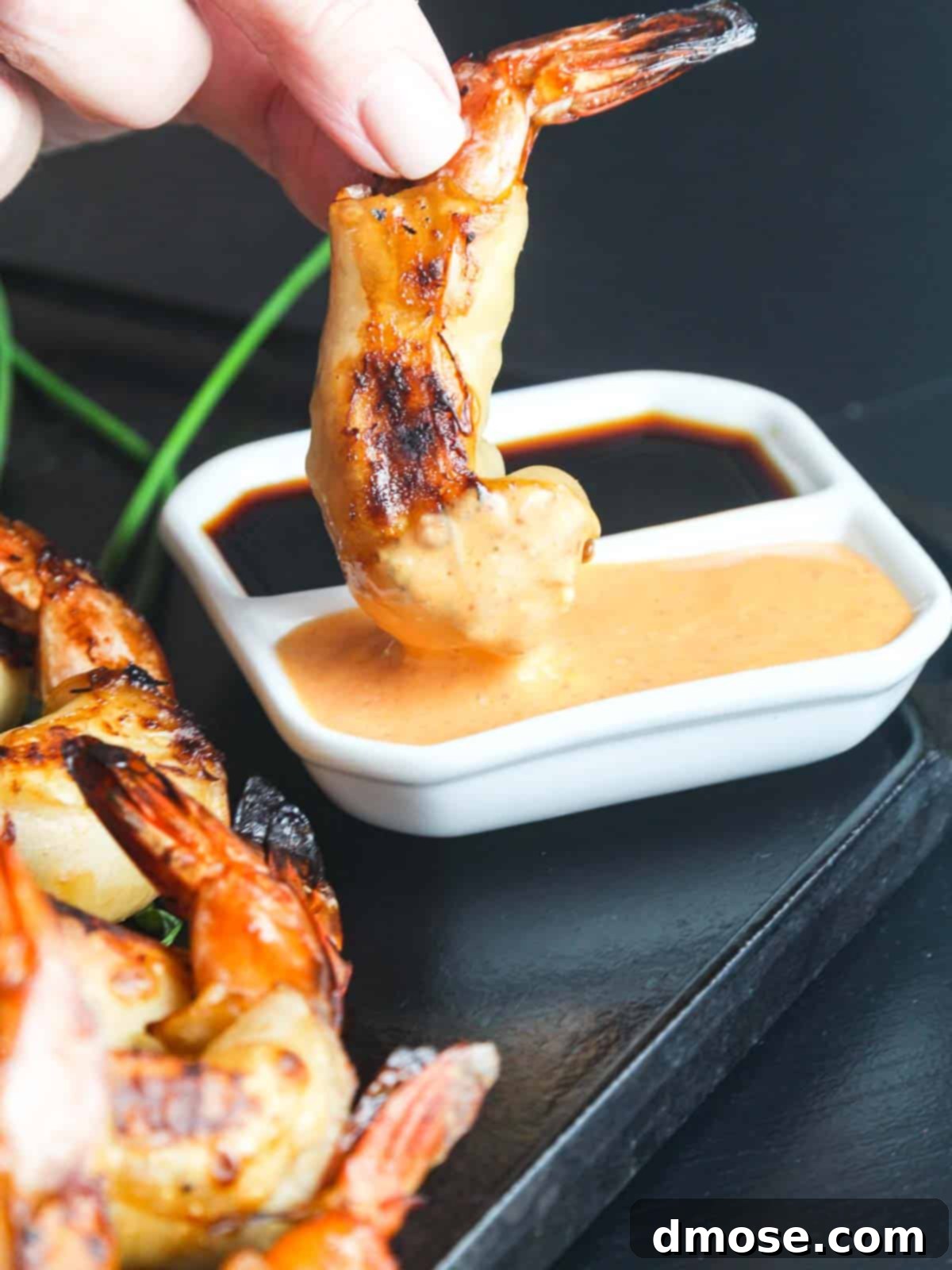 Hot Crispy Shrimp 3 Close-up of a Firecracker Shrimp being dipped into sriracha sauce.