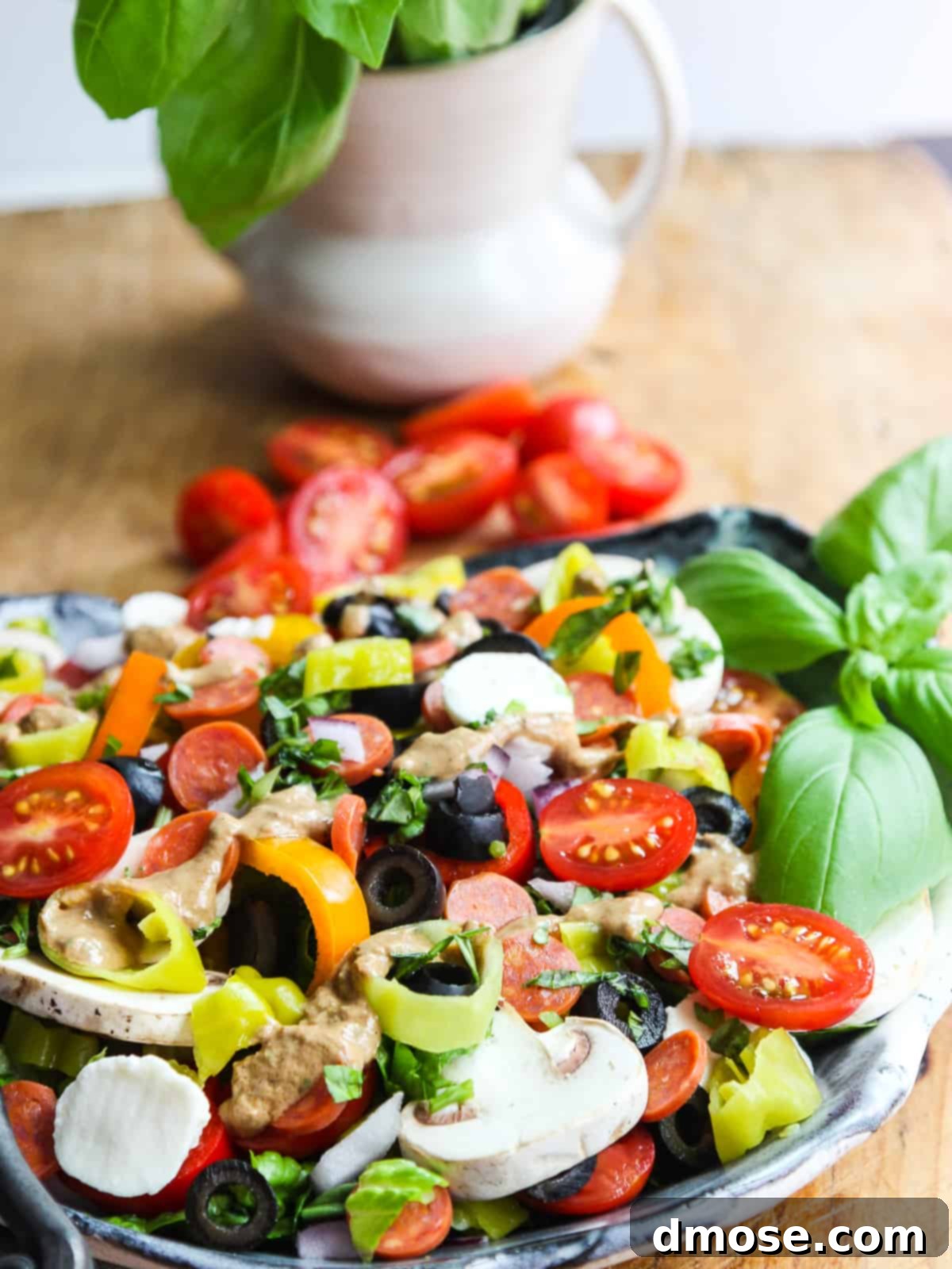 A close-up shot of a Pizza Salad on a white ceramic plate, showcasing the various colorful toppings and the creamy dressing.
