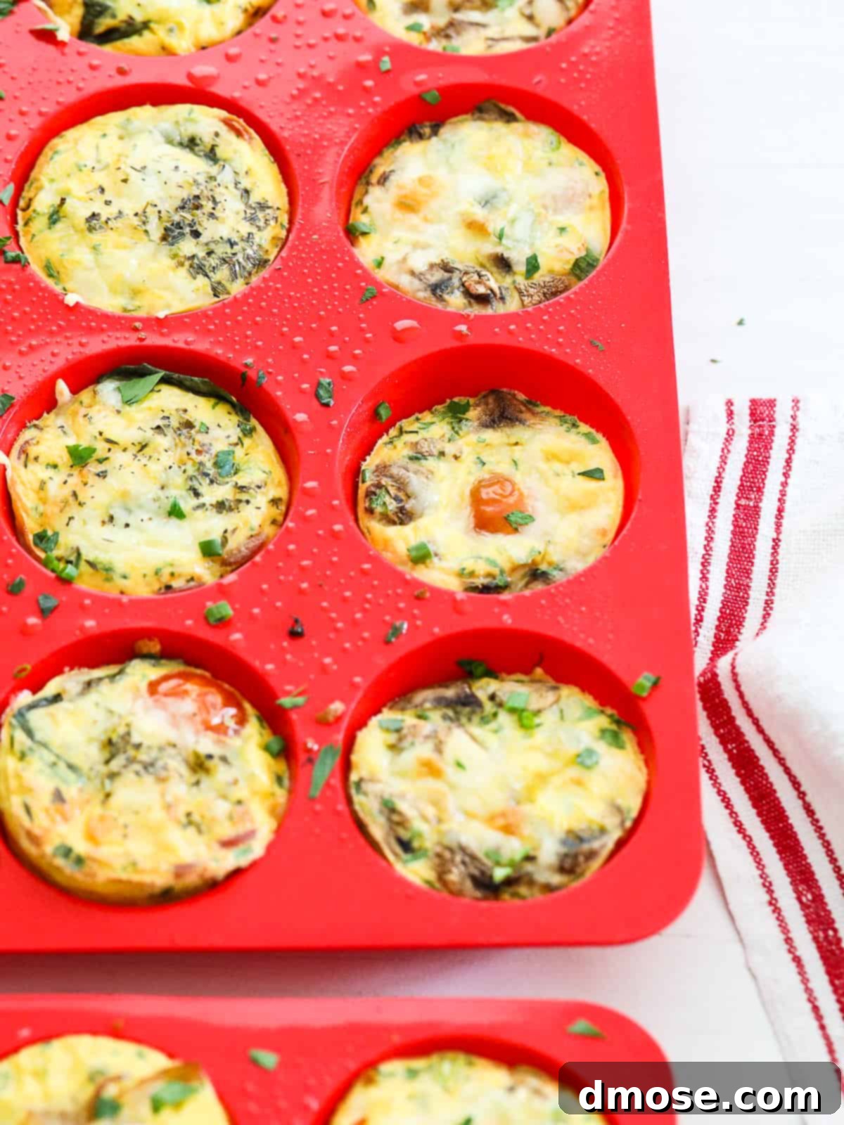 Baked Egg Muffins still in red muffin trays, showcasing their golden texture.