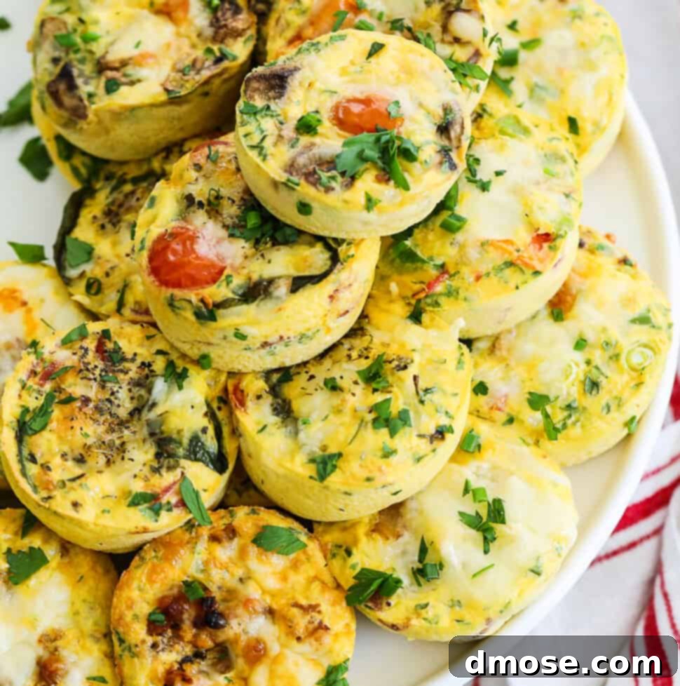 Small round breakfast egg muffins stacked on a white cake plate for a brunch or breakfast filled with different flavors.