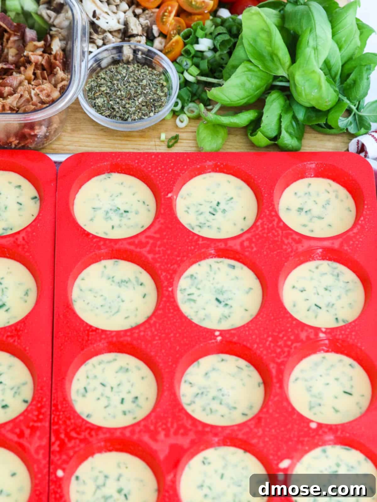 Muffin trays filled with egg mixture, prior to adding toppings and baking.