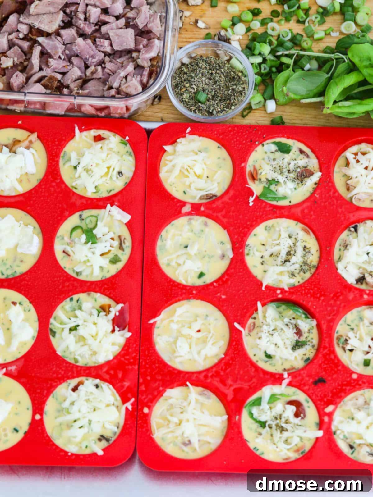 Egg muffins in a muffin tin before baking, showing various toppings.