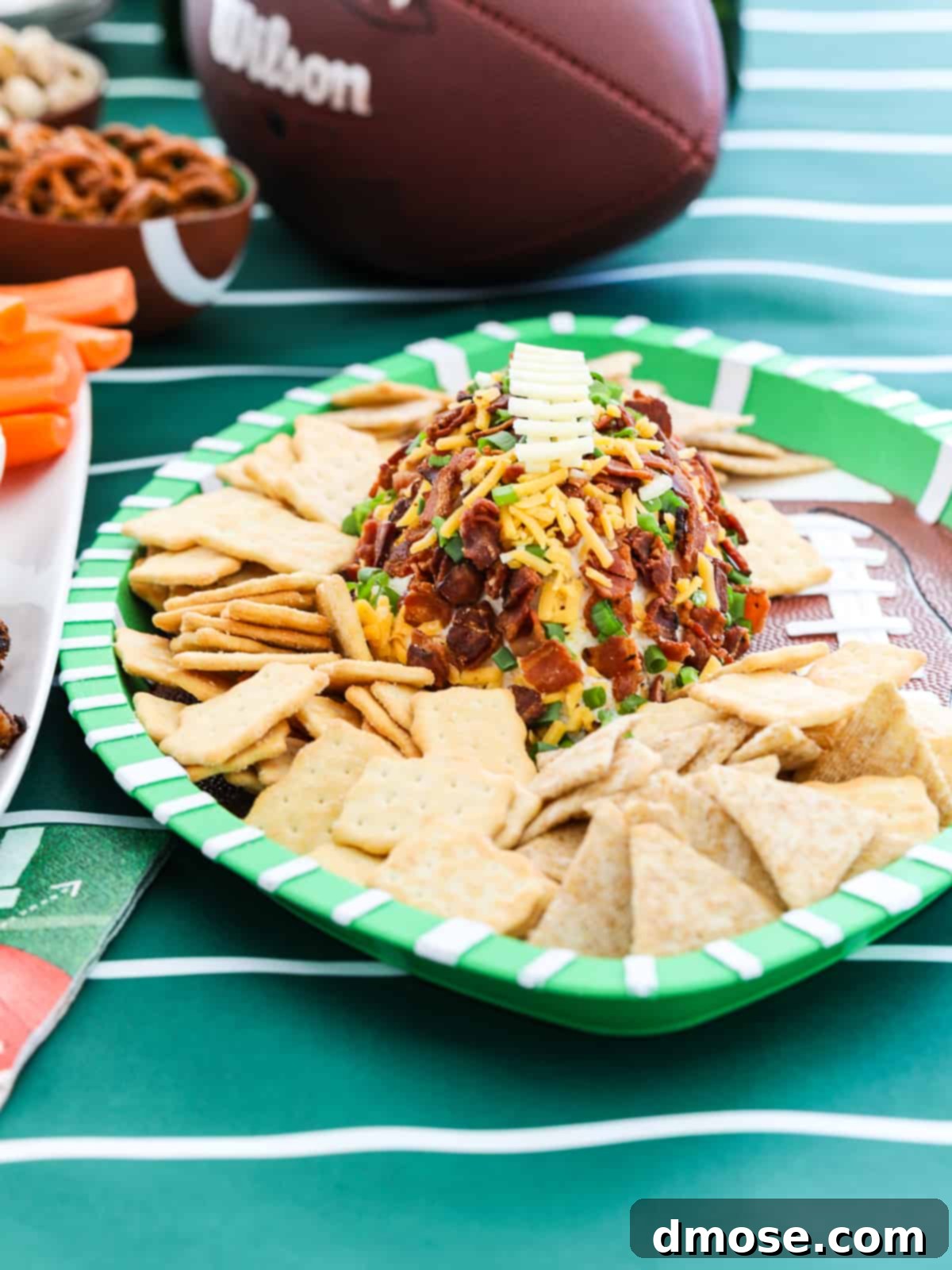 A festive game day party setup with a large variety of food, including a football-shaped cheese ball, surrounded by friends enjoying the event.