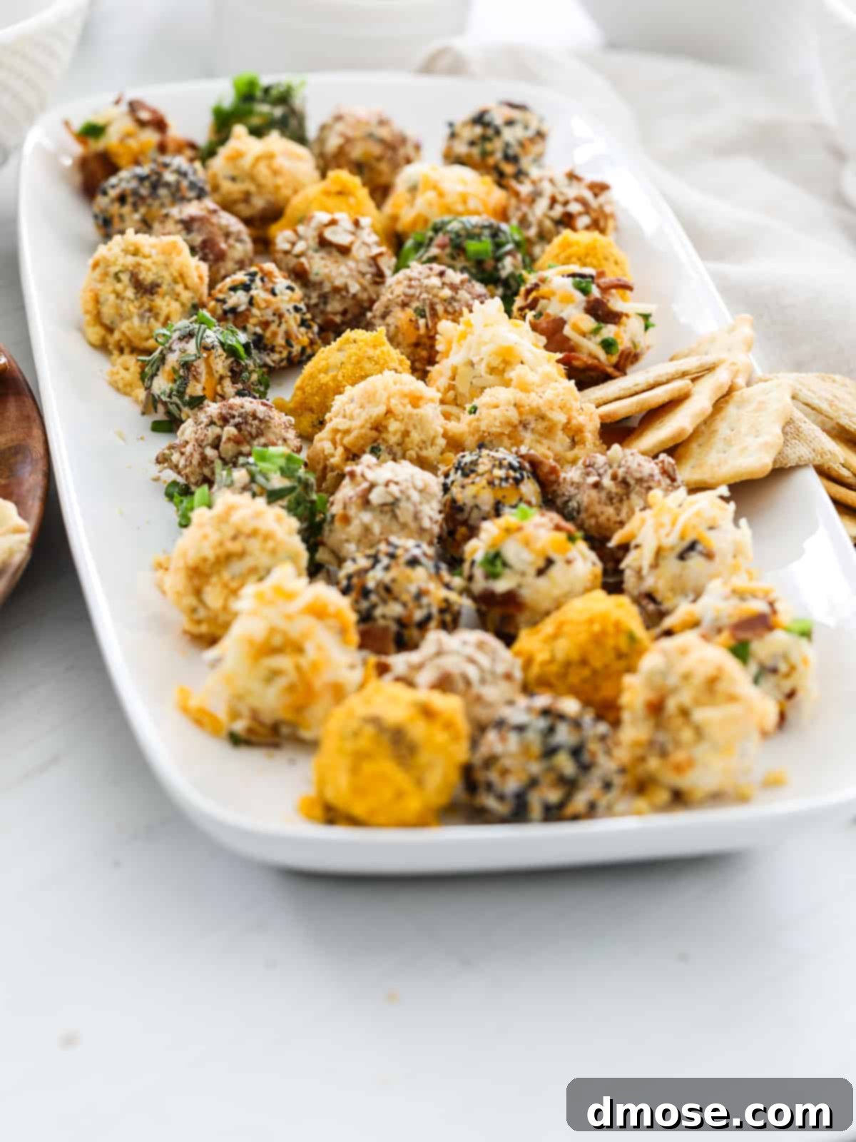 Gourmet Cheese Truffle Bites 12 Side view of a platter filled with mini cheese truffle cheeseballs, each with different toppings.