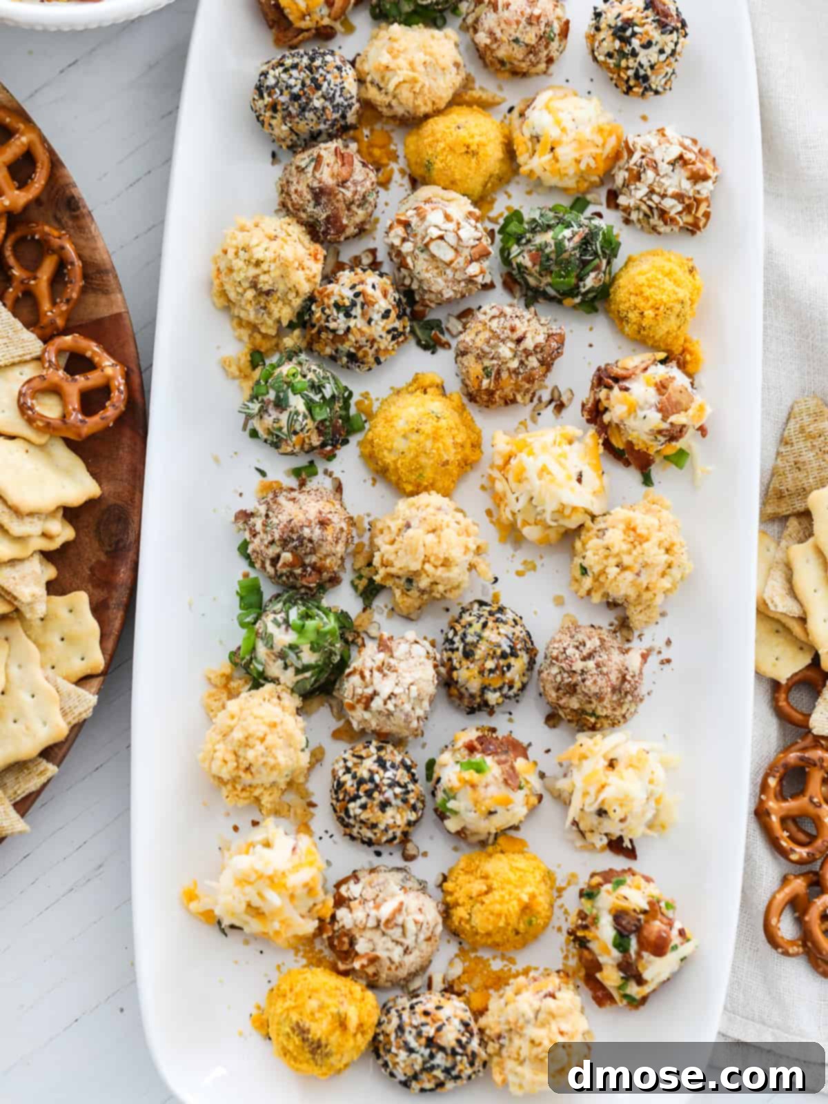 Gourmet Cheese Truffle Bites 14 Cheese truffles on a platter with crackers and pretzels, showcasing different topping varieties.