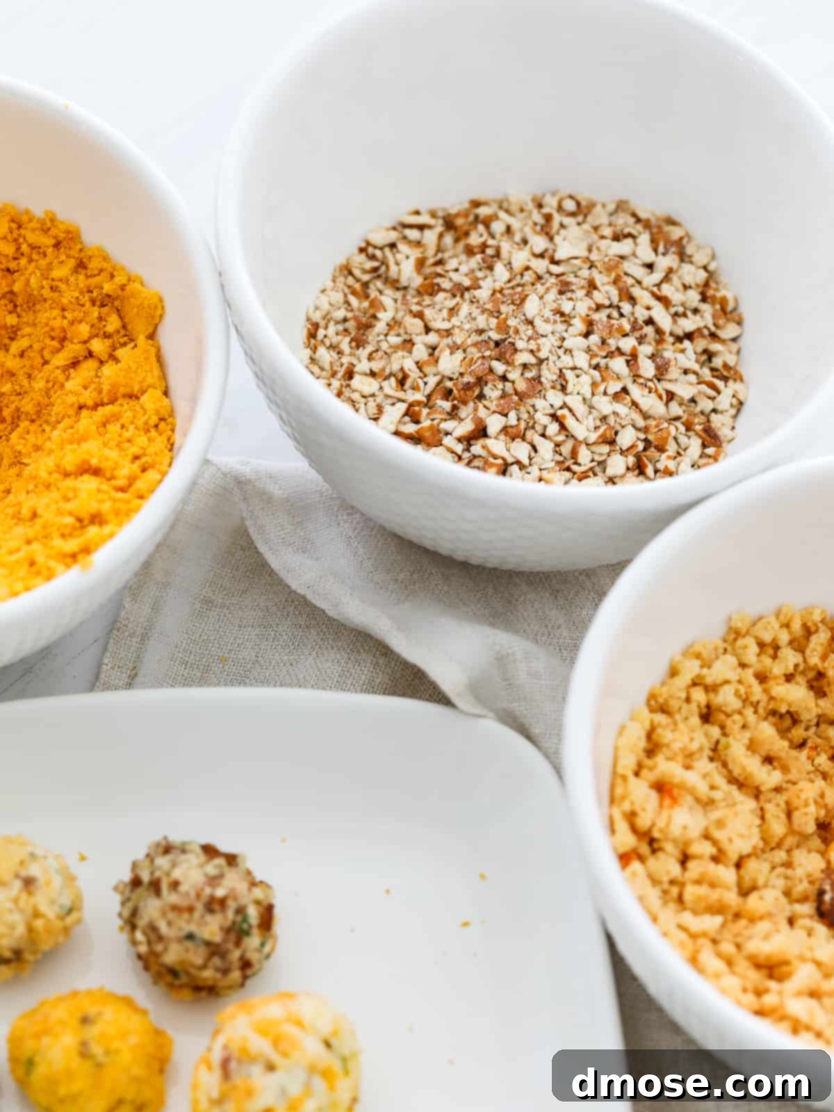 Gourmet Cheese Truffle Bites 4 A selection of small bowls filled with various toppings for cheese truffles, including nuts, herbs, and cheese.