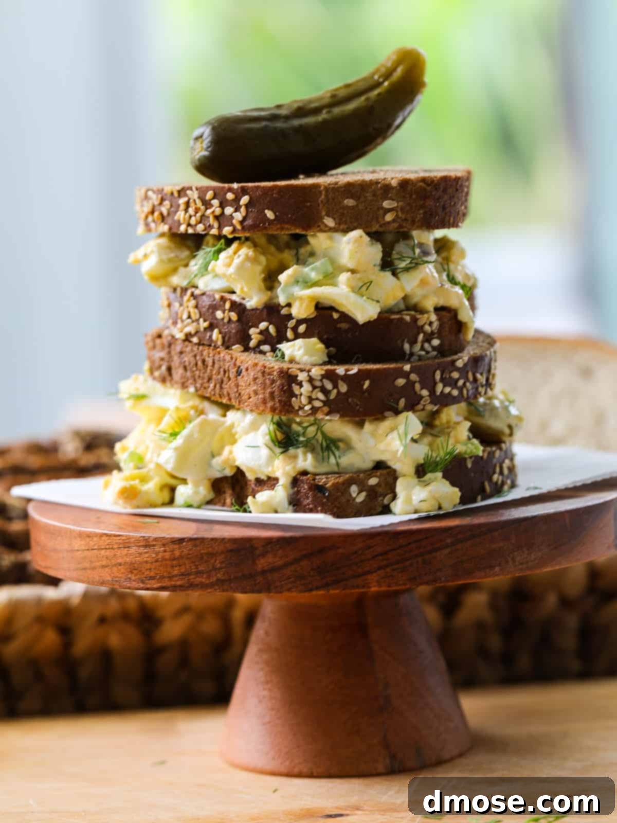 Savory Egg Salad Sensation 2 Delicious egg salad sandwich with fresh dill on pumpernickel bread, sliced in half.