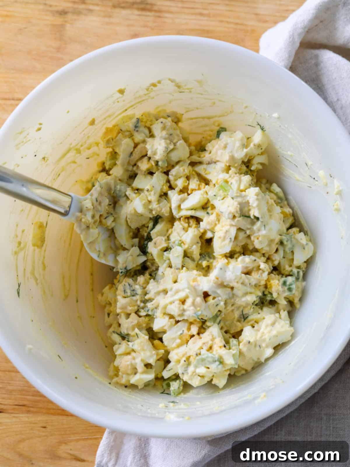 Savory Egg Salad Sensation 8 Mixing egg salad in a bowl with a spatula.