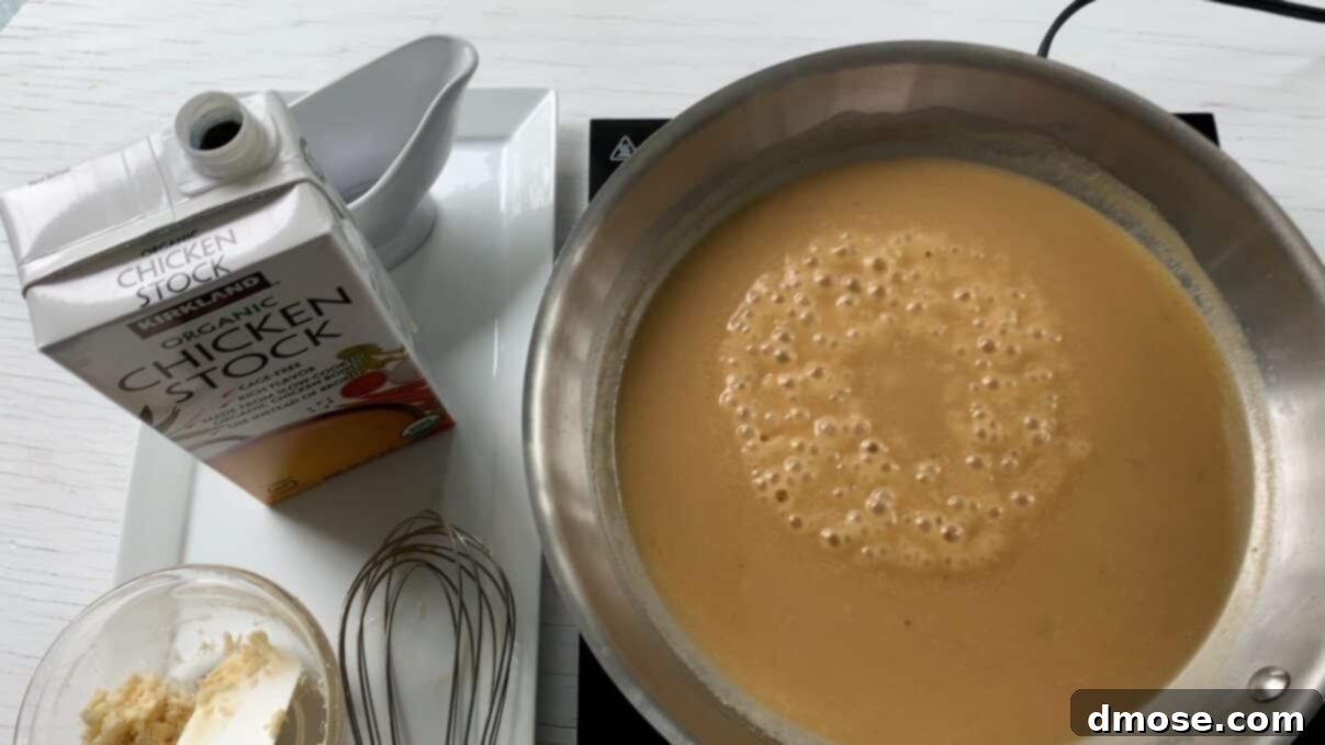 Savory Turkey Gravy 11 Delicious turkey gravy bubbling gently in a saucepan, showing its rich, thick consistency.