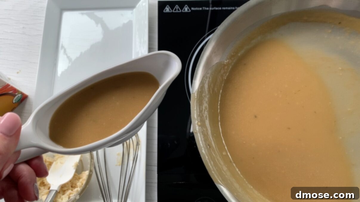 Savory Turkey Gravy 13 A full gravy boat of turkey gravy on a wooden cutting board, with the saucepan in the background.